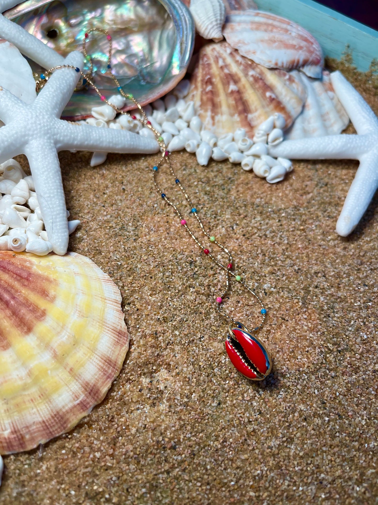 One of a kind. Gold and rainbow necklace with a Red cowrie shell