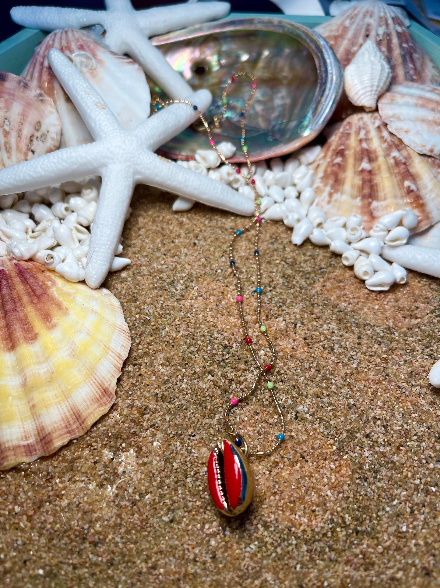 One of a kind. Gold and rainbow necklace with a Red cowrie shell