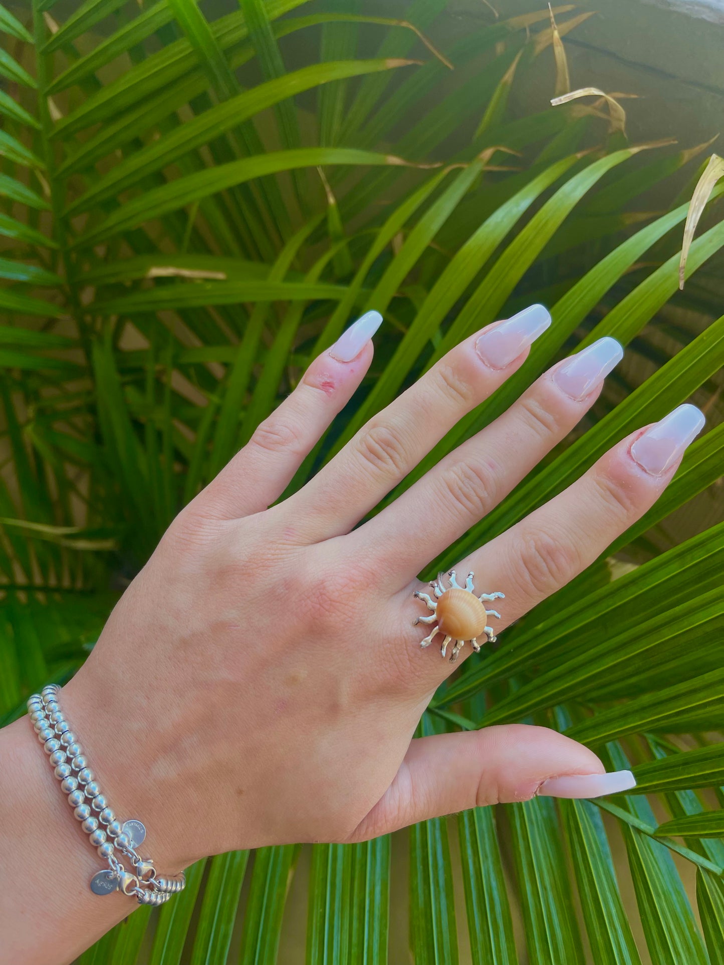 Silver sun and orange seashell ring